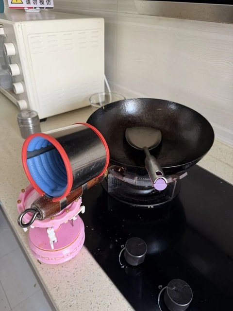 失去双手的张斌用自己改制的锅具和锅铲