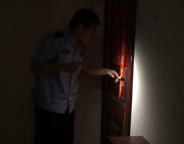 合道街某居民楼顶楼的保险窗上站着一个